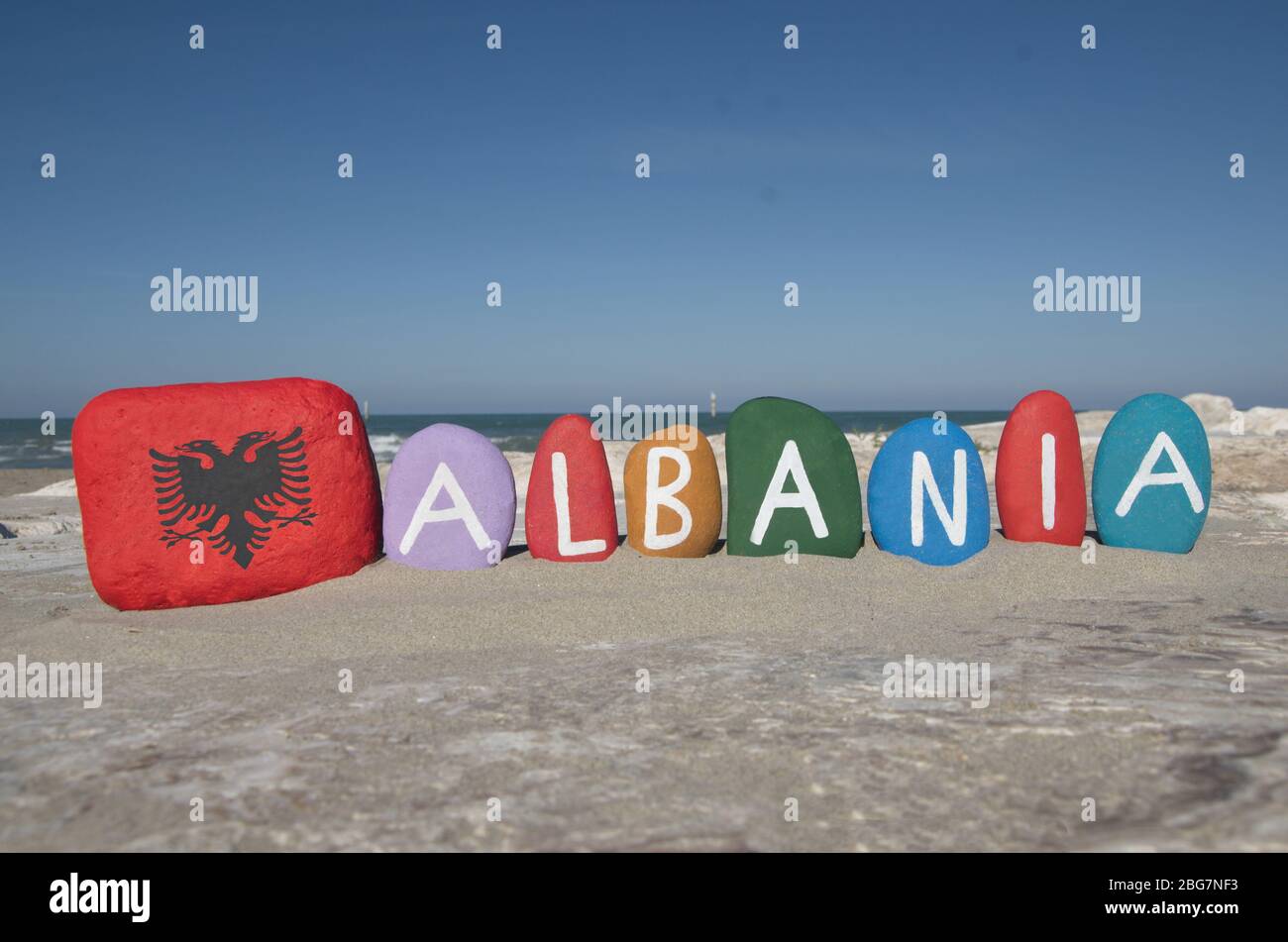 Albanien mit Nationalflagge, zusammengesetzt mit bunten Steinbuchstaben am Strand Stockfoto