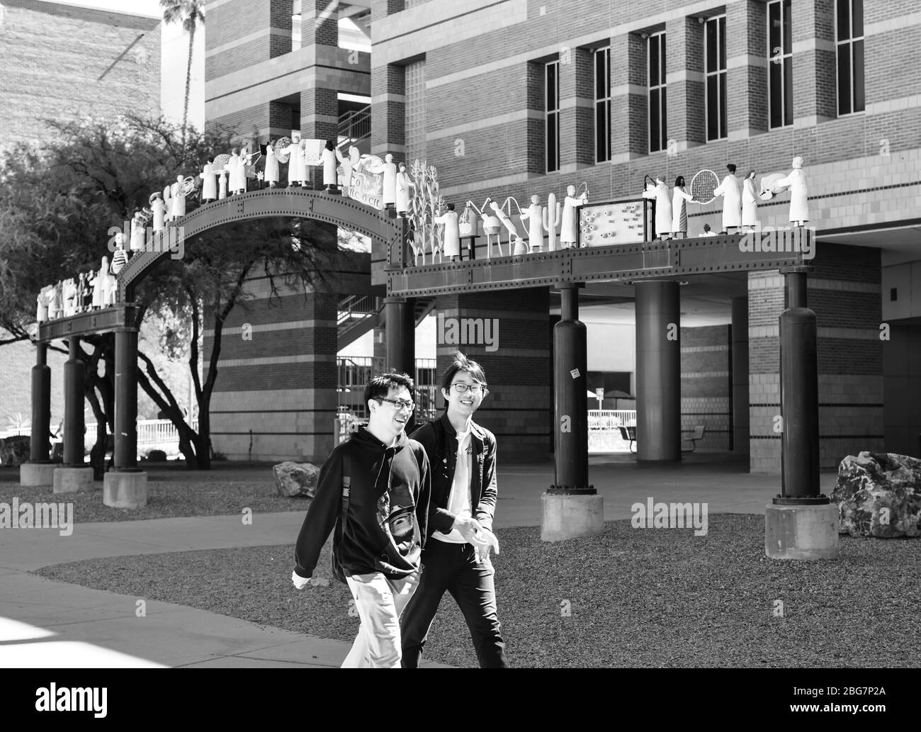Zwei junge Männer asiatischer Abstammung lachen vor dem Henry Koffler Gebäude mit den Skulpturen der Wissenschaftler an der Universität von Arizona, Tucson, AZ Stockfoto
