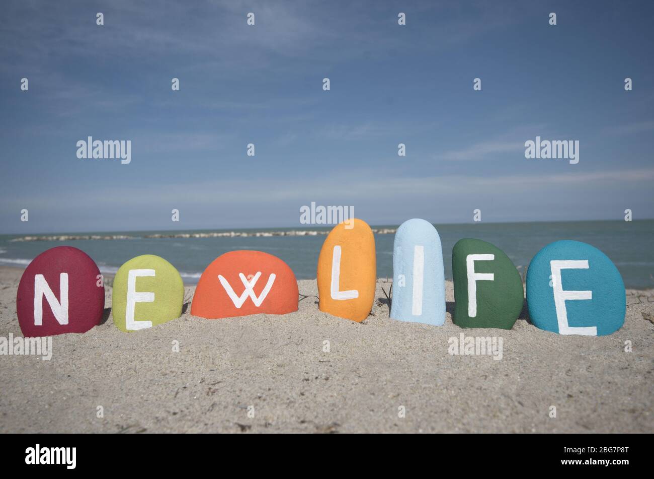 Neuer Lebenstext mit mehrfarbigen Steinbuchstaben am Strand Stockfoto