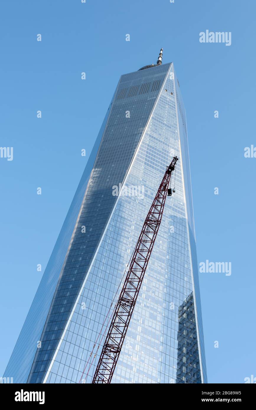 Freedom Tower Nahaufnahme mit großem, rotem Kran im Vordergrund vor blauem Himmel. Stockfoto
