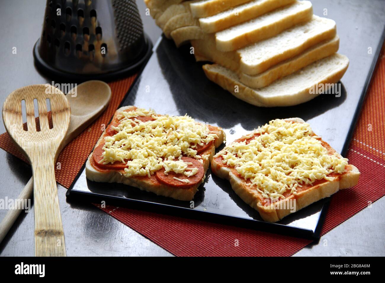 Foto von Brotscheiben mit Pizzabesticken aus Käse, Pepperoni und Tomatensauce. Stockfoto