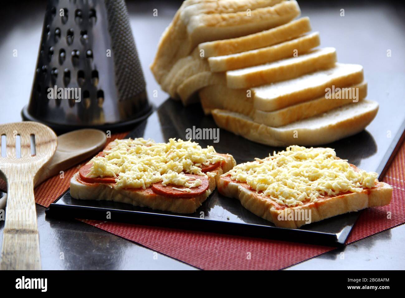 Foto von Brotscheiben mit Pizzabesticken aus Käse, Pepperoni und Tomatensauce. Stockfoto