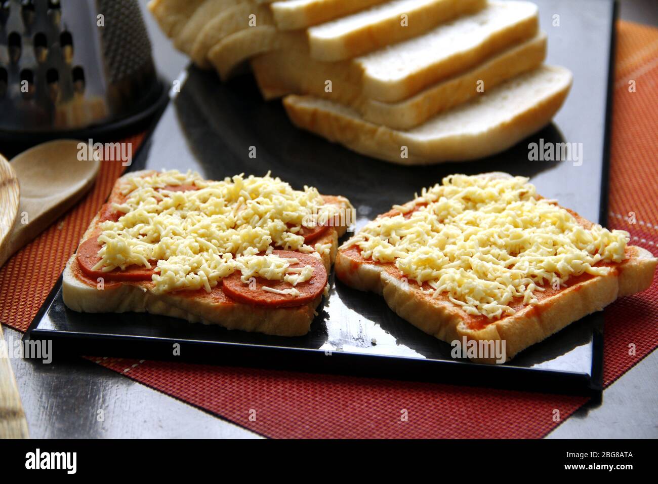 Foto von Brotscheiben mit Pizzabesticken aus Käse, Pepperoni und Tomatensauce. Stockfoto