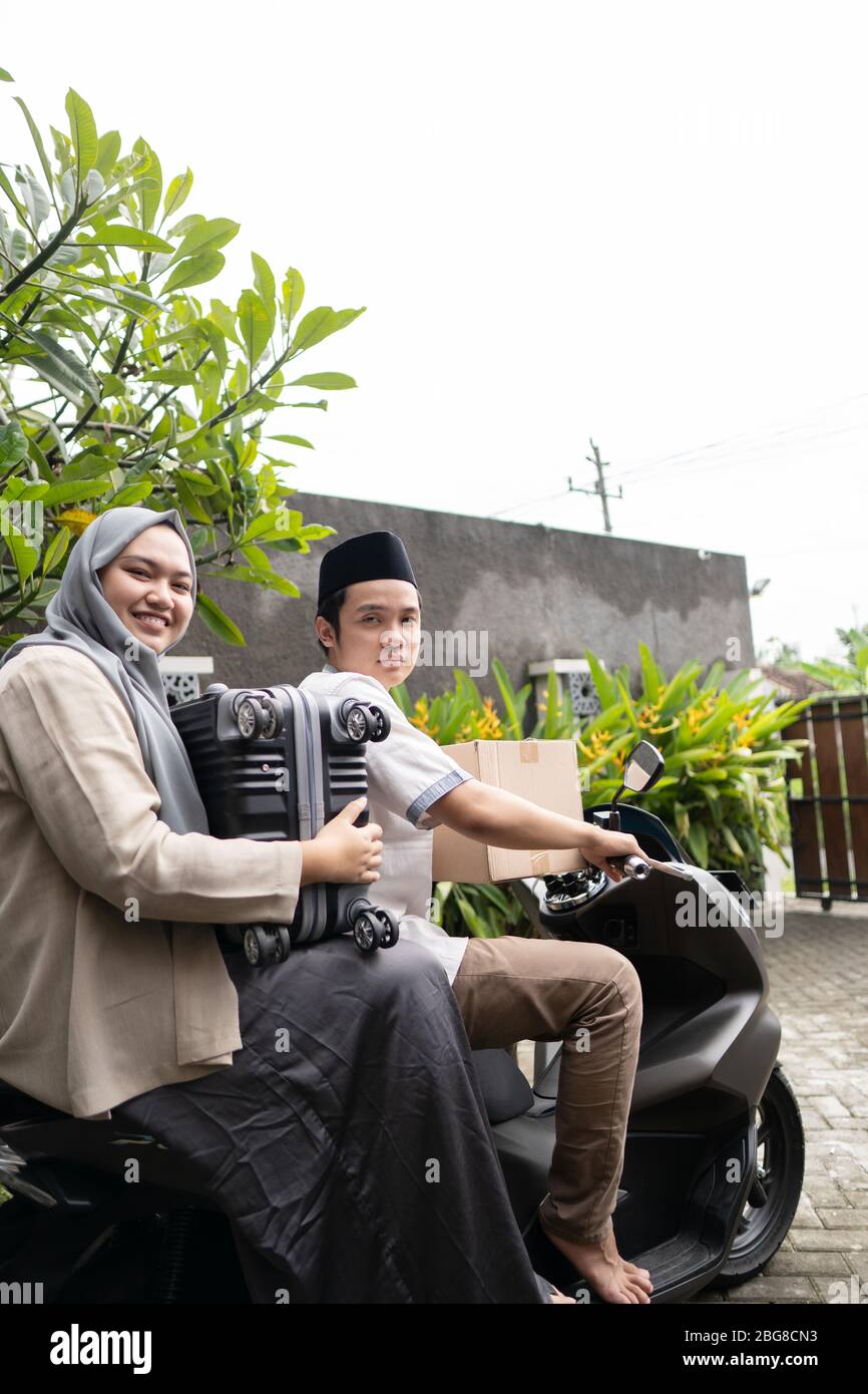 Asiatische muslimische Paare mit Motorrad-Mudik nach Hause gehen und tragen viele Gegenstände, um Eid zu feiern Stockfoto Asiatische muslimische Paare mit Motorrad-Mudik nach Hause gehen und tragen viele Gegenstände, um Eid zu feiern Stockfoto