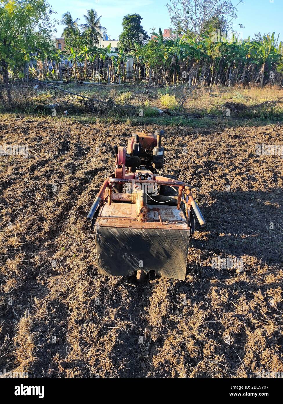 Handfarming Mini Traktor auf landwirtschaftlichen Flächen. Motorkultivator am chennai in der Kategorie. Roter Boden und blauer Himmel. Mini Farm Walking Traktor. Chennai Weit Stockfoto