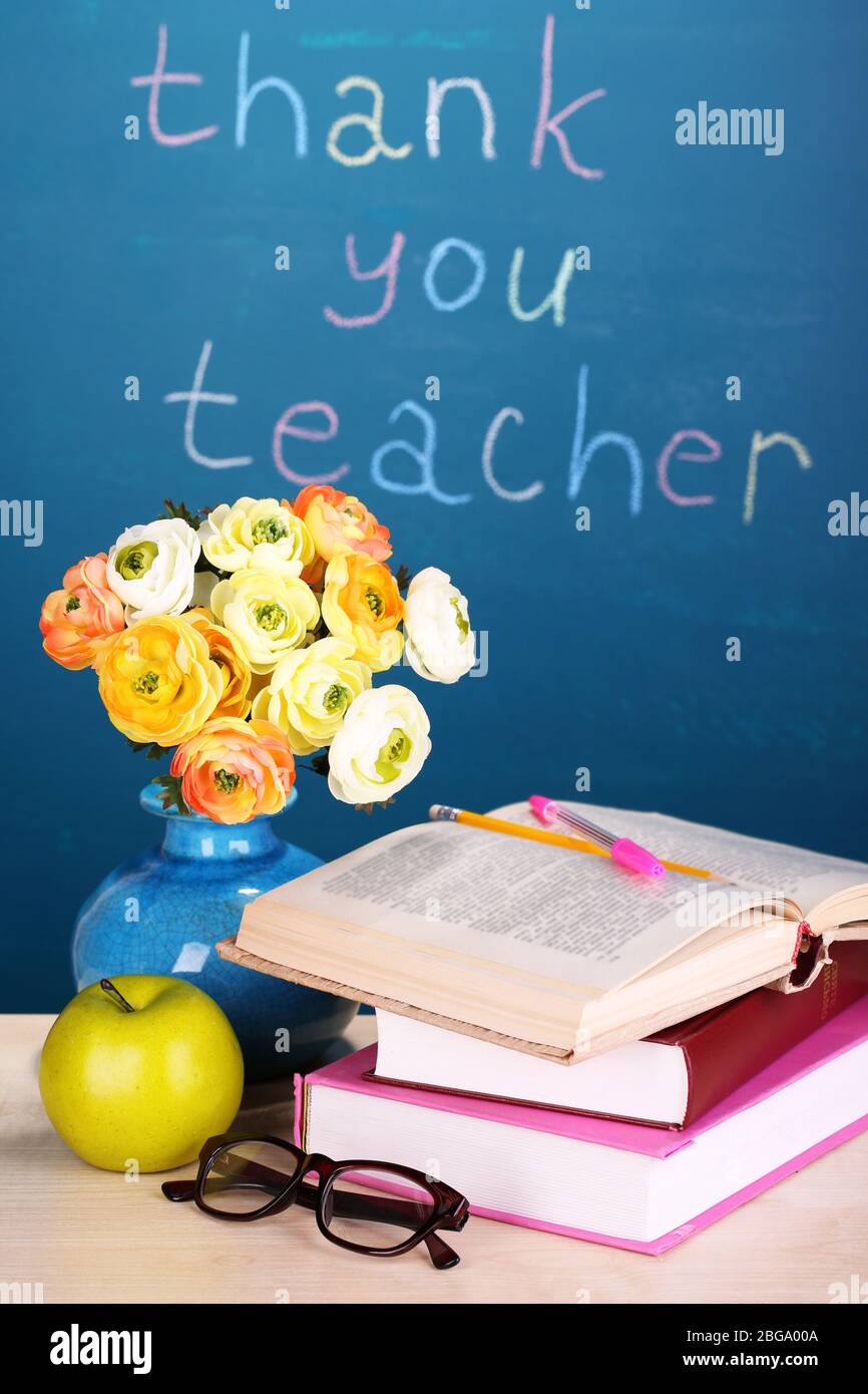 Schulbedarf und Blumen auf Tafel Hintergrund mit Inschrift Danke Lehrer Stockfoto