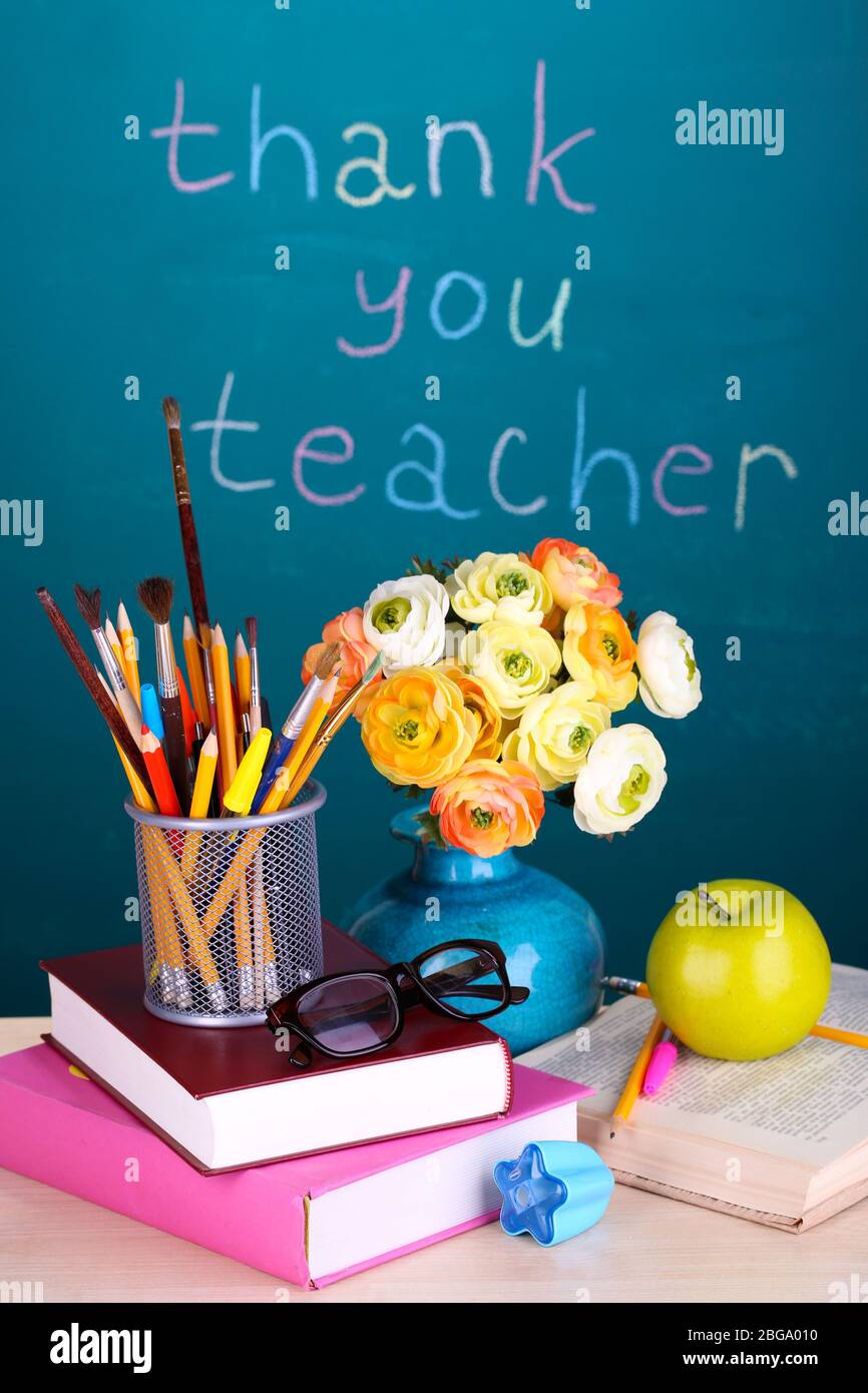 Schulbedarf und Blumen auf Tafel Hintergrund mit Inschrift Danke Lehrer Stockfoto