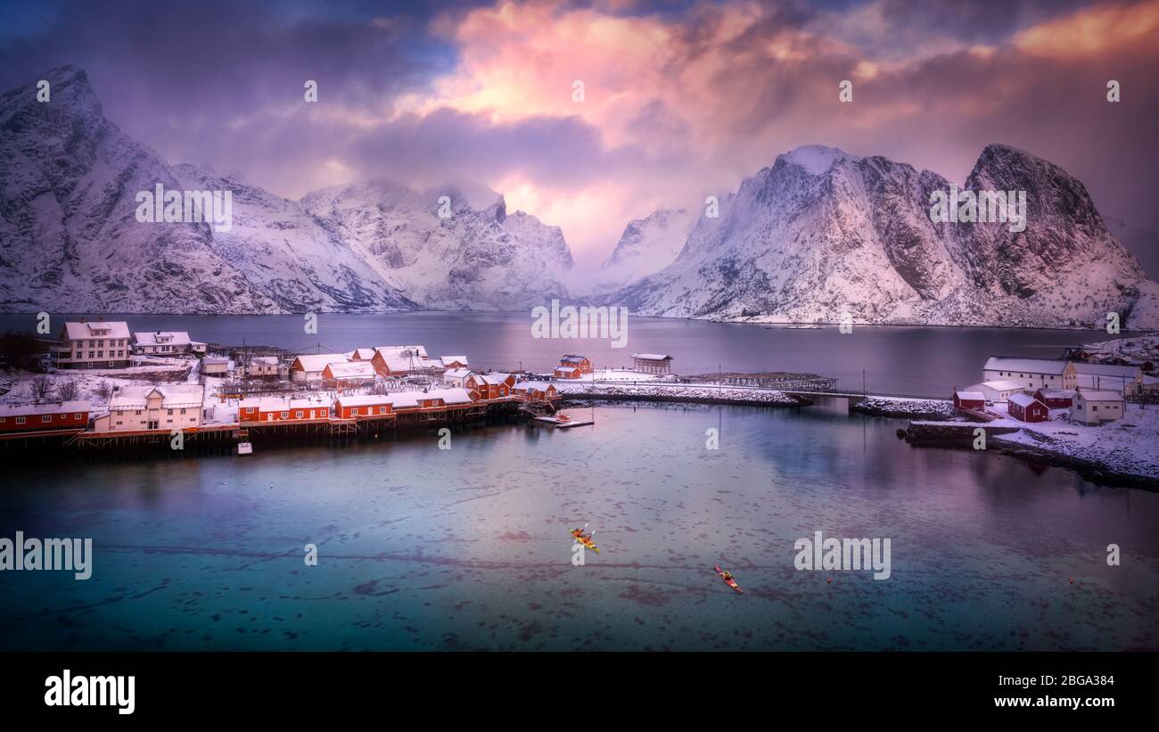 Das wunderschöne nordische Küstendorf reine, mit schneebedeckten Bergen, unberührtem Fjord und dramatischem Himmel. Stockfoto