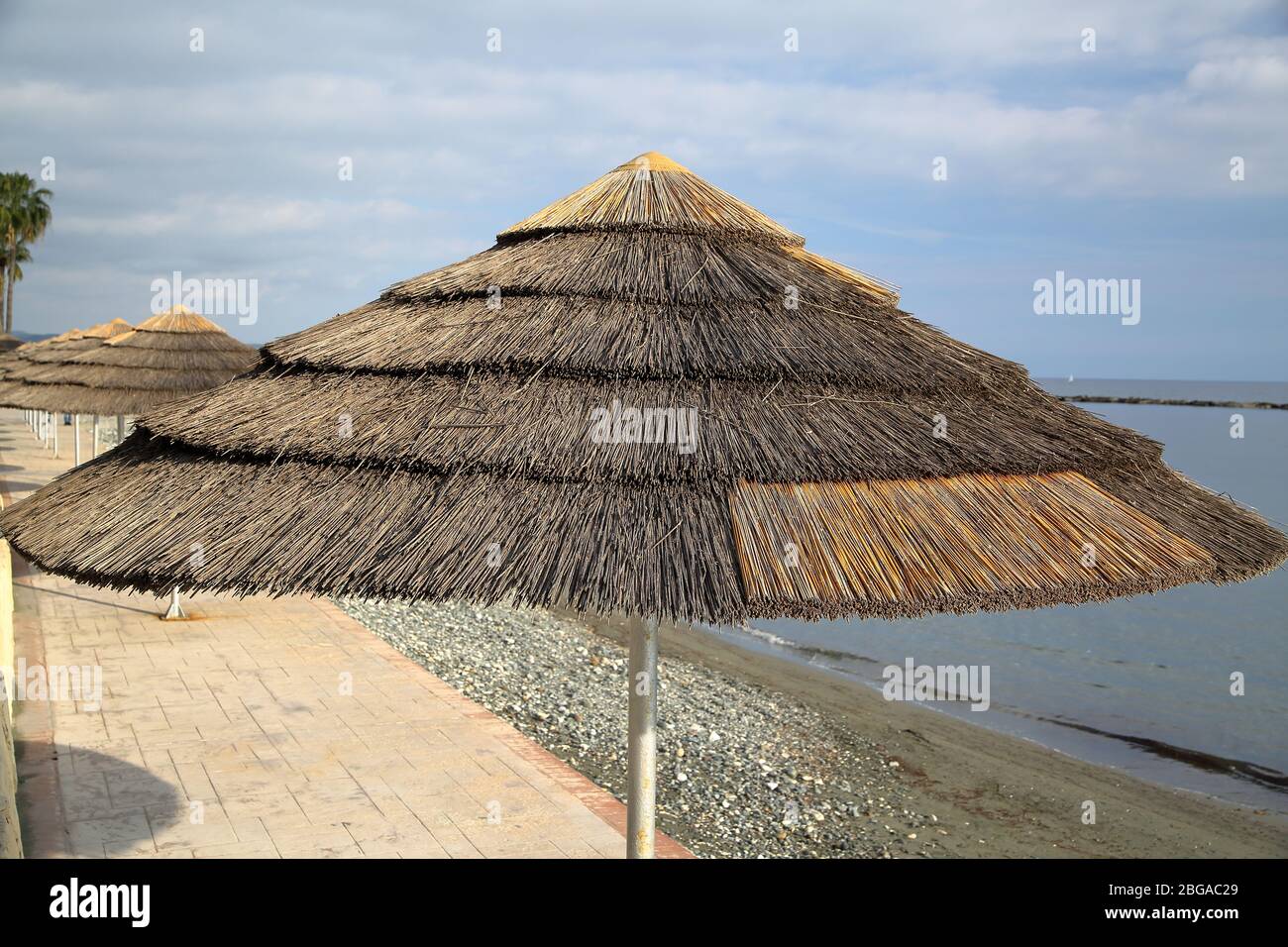 Schilf-Strandschirme am leeren Strand, ohne Menschen, Paphos, Zypern, beliebter Urlaub Sommerresort. Stockfoto