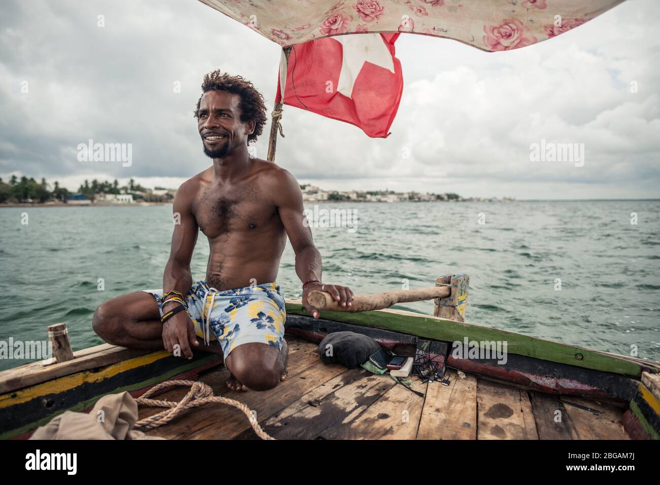 Lamu, Kenia - 15. Dezember 2016: Afrikanischer Segler im traditionellen Dhau-Boot bei der Insel Lamu Stockfoto