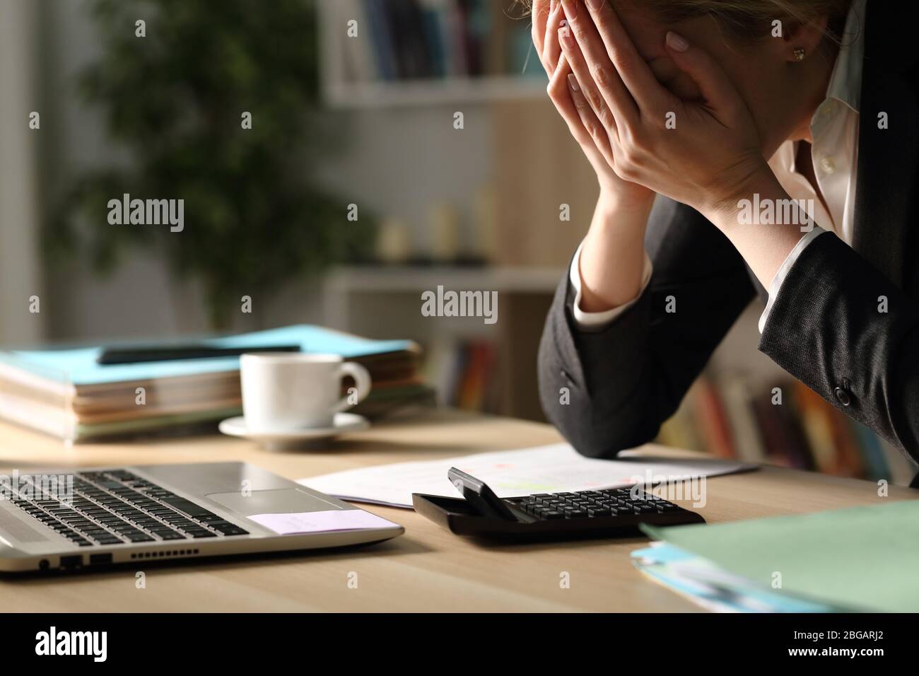 Nahaufnahme der Unternehmerin, die sich über schlechte Ergebnisse in der Nacht auf einem Schreibtisch im Home Office beschwert Stockfoto
