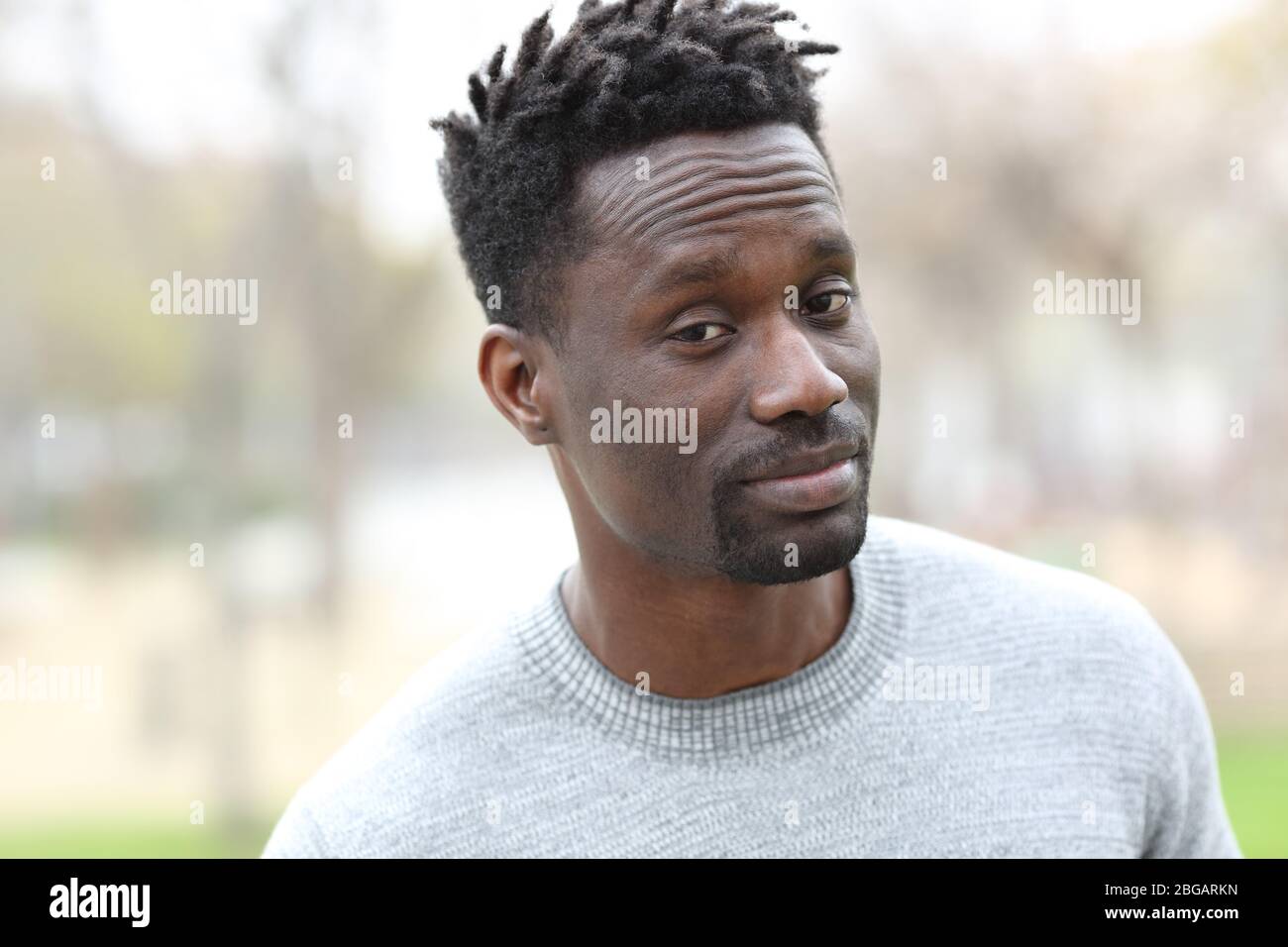 Verdächtiger schwarzer Mann, der im Freien in einem Park steht Stockfoto
