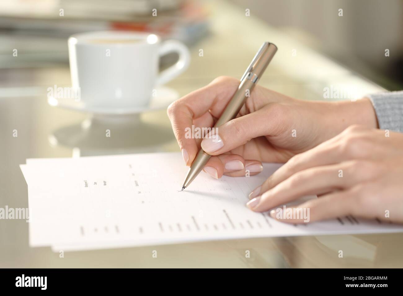 Nahaufnahme Seitenansicht der Frau Hand Ausfüllen Kontrollkästchen Formular auf einem Schreibtisch zu Hause Stockfoto