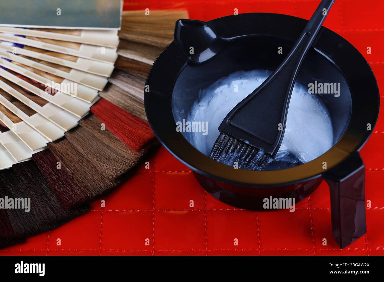 Zusammensetzung mit Haarproben in verschiedenen Farben, Pinsel und Farbe auf dem Tisch Hintergrund Stockfoto