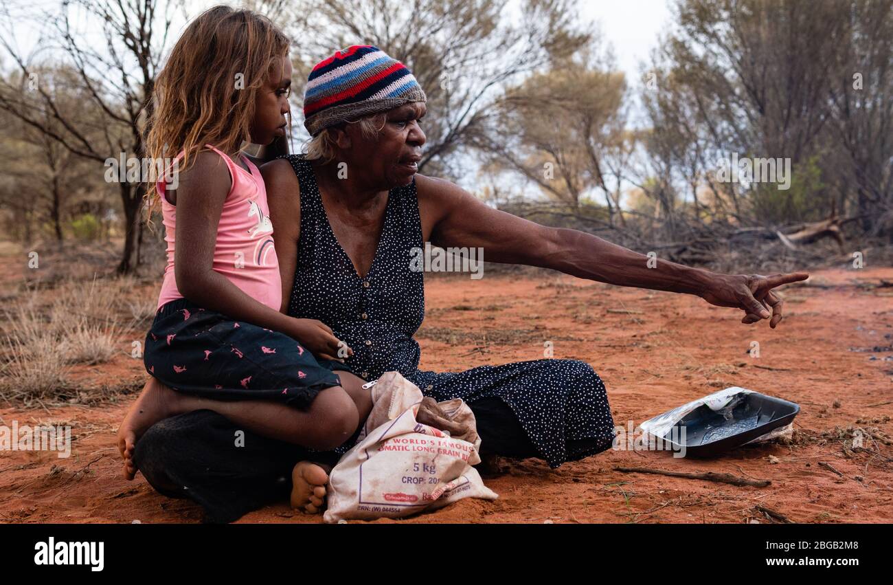 Yuendumu, NT Australie, Februar 15 2020 : Aborigines Warlpiri im Busch. Familie, Großmutter und Enkelin, nach der Jagd auf Honigameisen Stockfoto