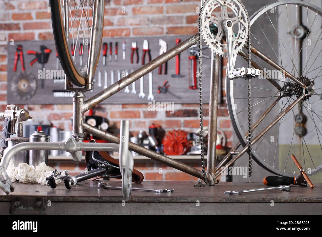 Vintage Fahrrad in der Werkstatt auf der Werkbank mit Werkzeugen, diy-Konzept Stockfoto