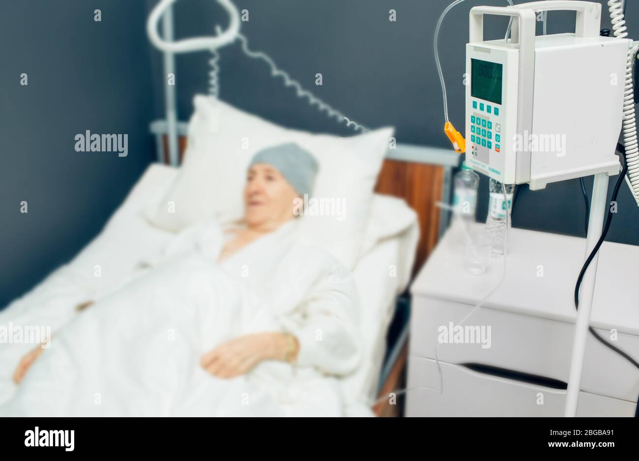Gerät für intravenöse Tropf-Chemotherapie in einer onkologischen Klinik. Ältere Frau, die während der Krebsbehandlung Chemotherapie durch Infusionsanschluss erhält Stockfoto