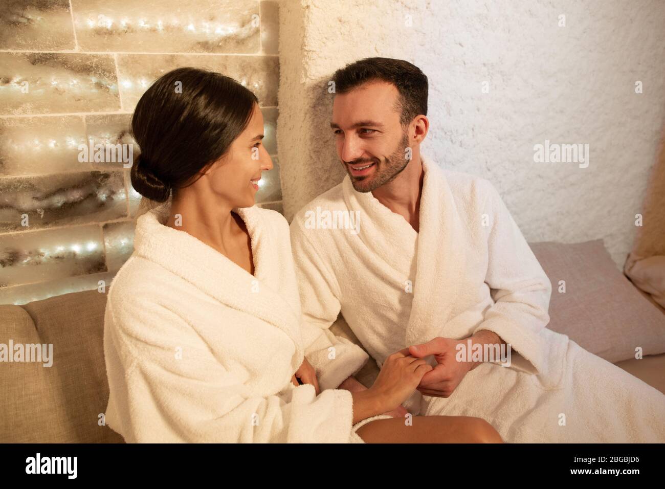 Gemischte Paare genießen Salzraumtherapie im Spa-Salon. Körperbehandlung im Salzraum Stockfoto