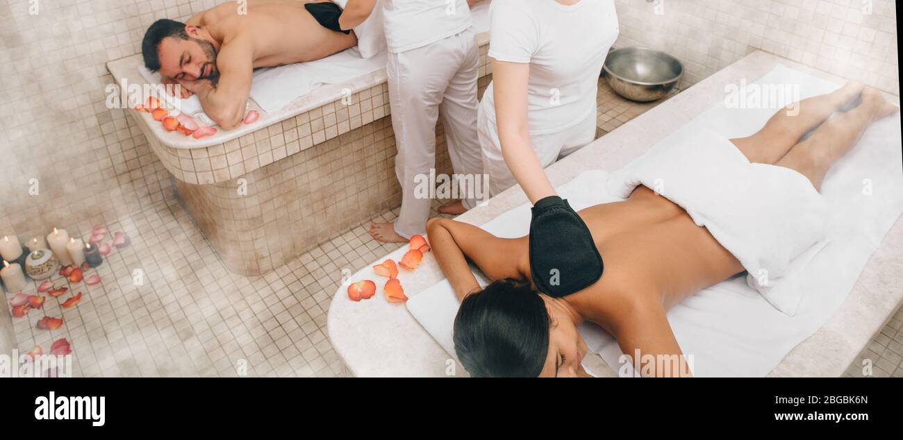 Gemischte Rasse Paar genießen Hammam, während türkische Bad Arbeiter ihren Körper füllen Stockfoto