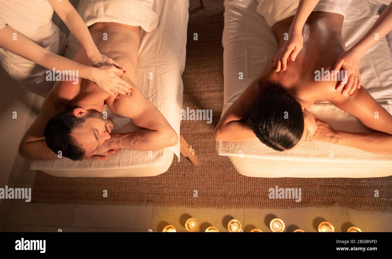 Paarmassage mit Aromaöl, Draufsicht. Gemischte Rasse Paar verbringen Zeit zusammen und genießen Romantik-Massage, Spa-Resort. Stockfoto