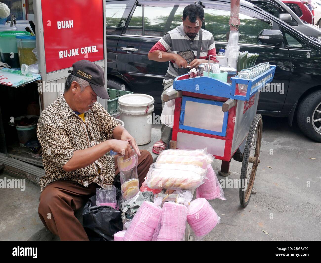 Ein Straßenverkäufer putzt seine Ware auf. Stockfoto