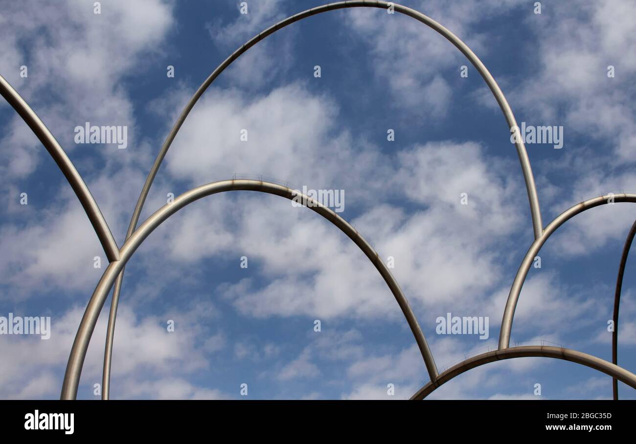 Blick auf gigantische, moderne Skulptur mit wolkig blauem Himmel im Hafen von Barcelona. Es wird Wellen (Onades) von Andreu Alfaro genannt. Es ist ein sonniger Summe Stockfoto