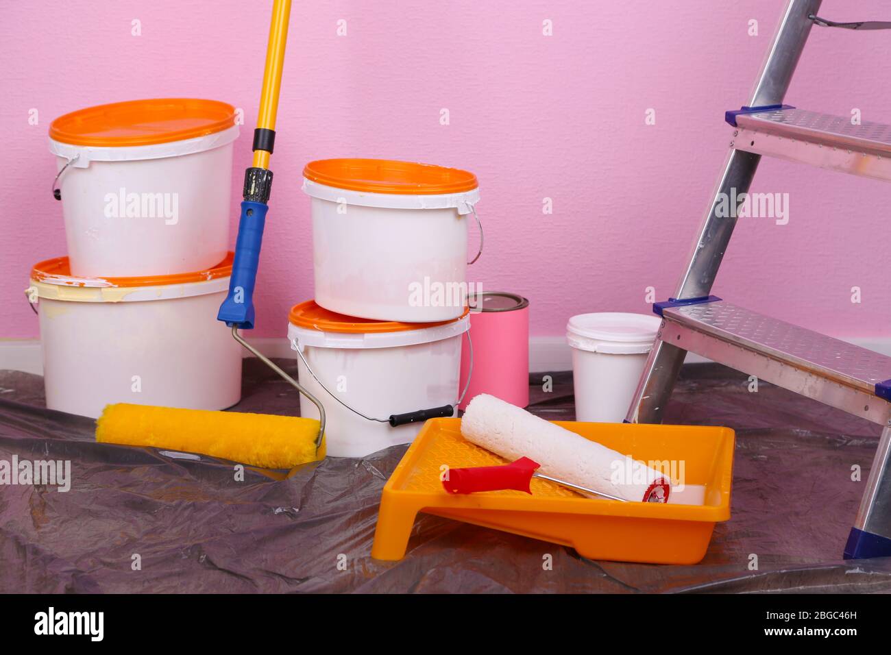 Eimer mit Farbe und Leiter auf Wand Hintergrund. Konzeptuelles Foto von Reparaturarbeiten im Raum Stockfoto