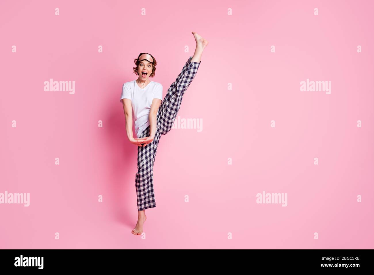 Ganzkörper-Foto von lustigen Dame heben Bein hoch Schlummer Nacht Party  präsentiert perfekte spannende Agilität tragen Schlafmaske weiß T-Shirt  karierten Pyjama Stockfotografie - Alamy