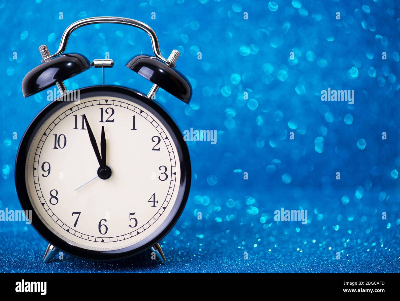 Wecker auf blauem Glitzer-Hintergrund Stockfotografie - Alamy