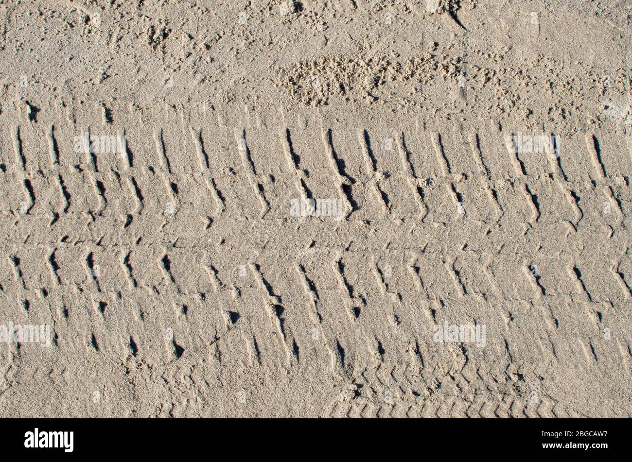 Reifenspur auf gelbem Sand Stockfoto