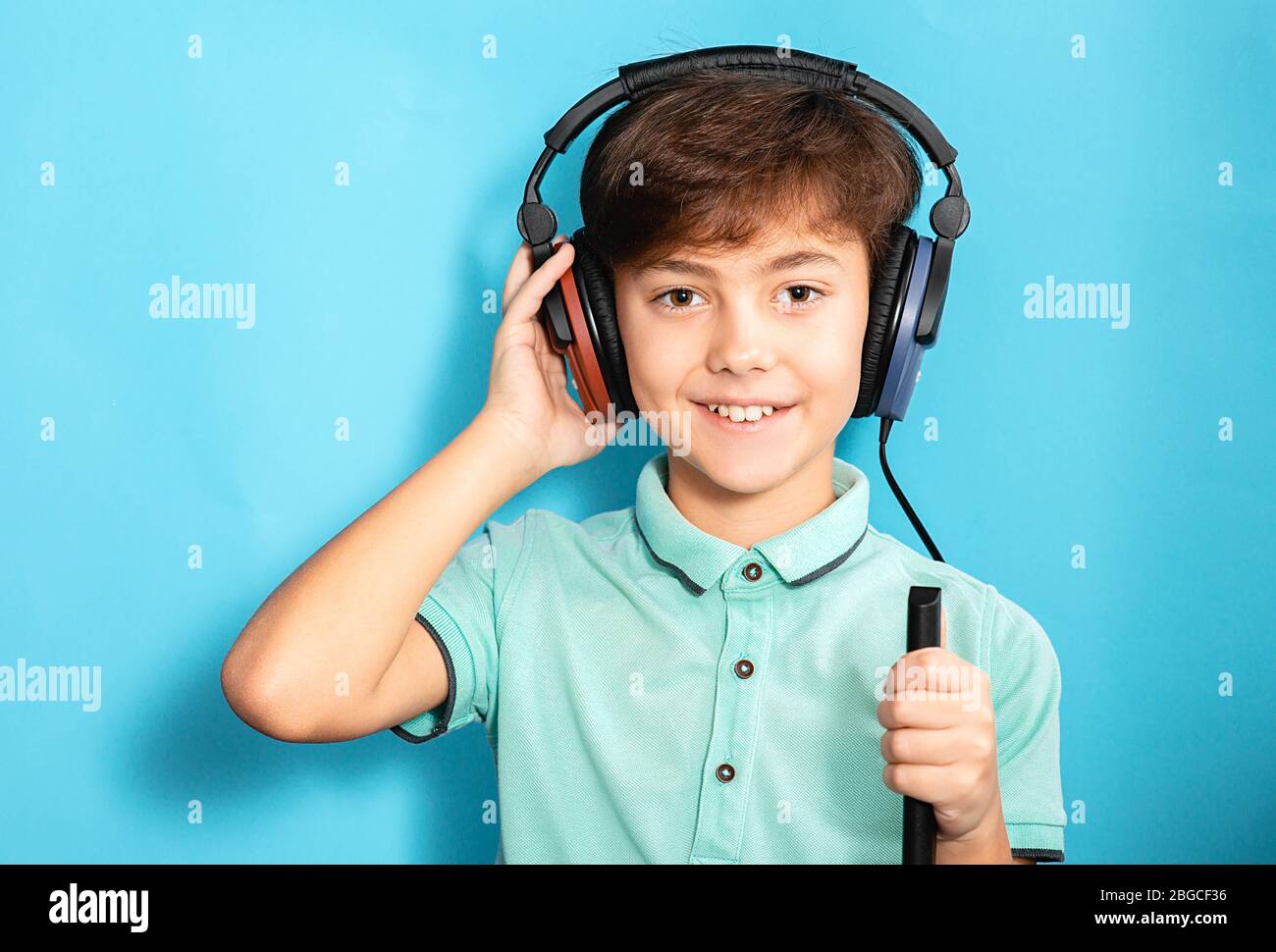 Positive kleine gemischte Rasse Junge trägt Kopfhörer mit exam.audiometry Test hören Stockfoto