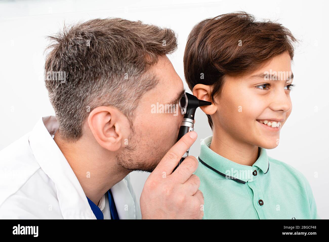 Kinderarzt Untersuchung wenig gemischten Rasse Kind mit Otoskop, Hörprüfung des Kindes Stockfoto