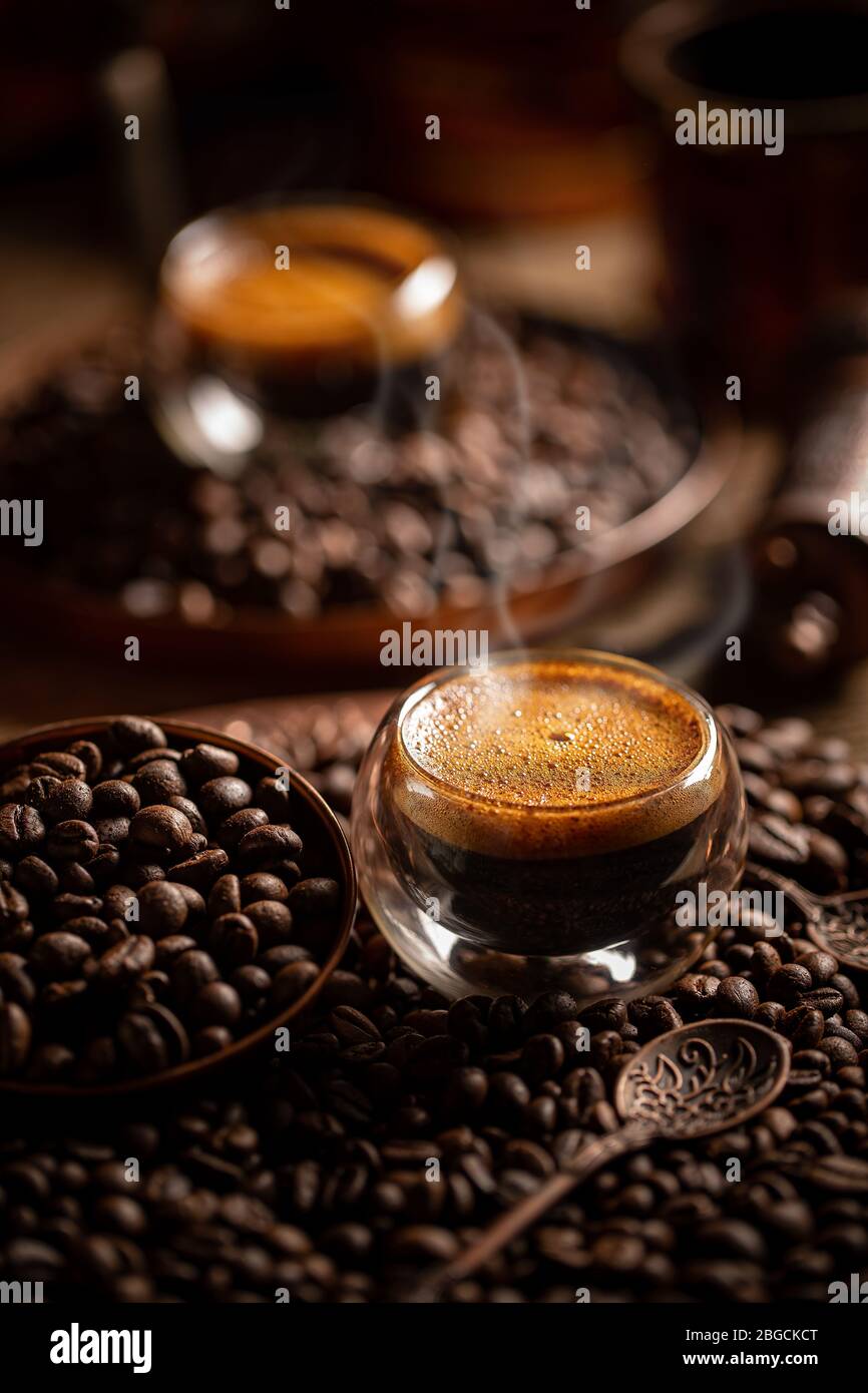 Espresso in doppelwandigen Glas Tasse auf gerösteten Kaffeebohnen Hintergrund Stockfoto