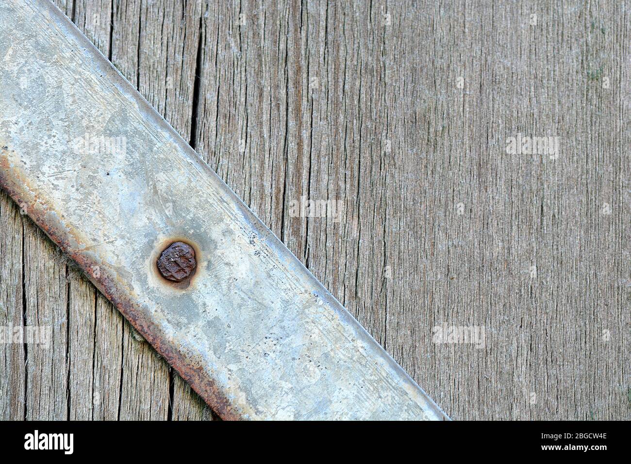 Metallplatte mit Schrauben über dem hölzernen Hintergrund Stockfoto