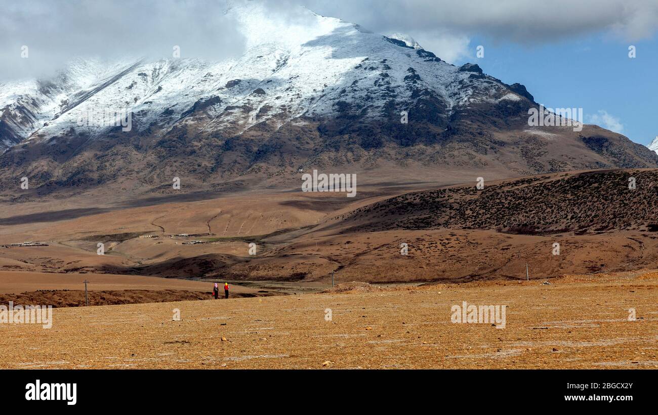 Landschaft von der Reise nach Norden von Lhasa nach Damshung, Tibet. In der Nähe des Mt. Nyanchen Tangla Aussichtspunkt, 4640m Höhe. Zwei Frauen auf dem Heimweg Stockfoto