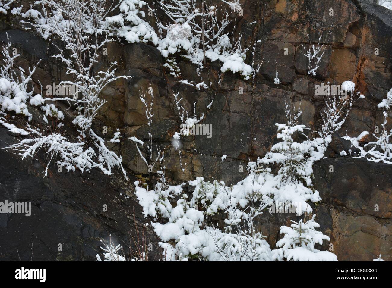 Frischer weißer Schnee auf dunklem Granitfelsen Stockfoto