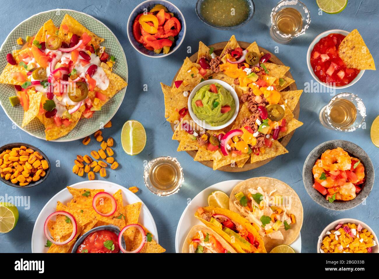 Mexikanische Auswahl an Speisen, von oben aufgenommen. Nachos, Guacamole, Tequila, Tacos und andere Gerichte, eine flache Lage Stockfoto