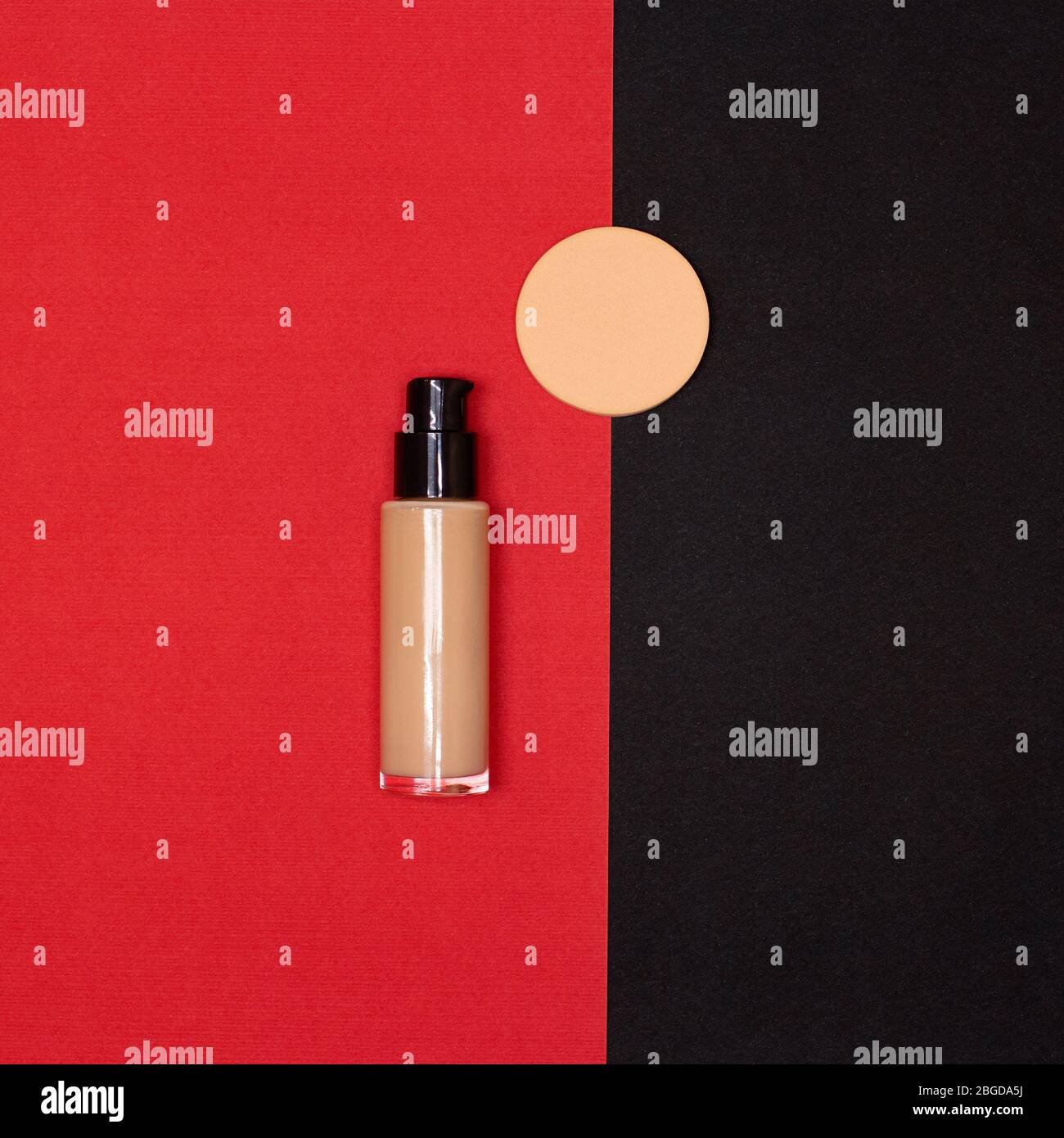 Make-up Foundation Flasche mit Make-up Schwamm auf rotem und schwarzem Hintergrund Flatlay Stockfoto