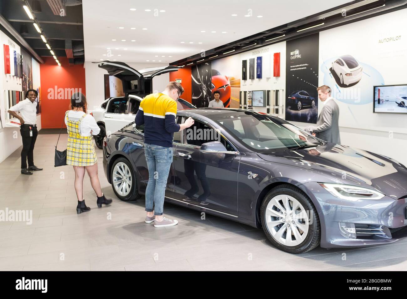 Kunden, die im Showroom der Tesla Automotive Company in der Mall am Cribbs Causeway, Bristol, Großbritannien, stöbern Stockfoto