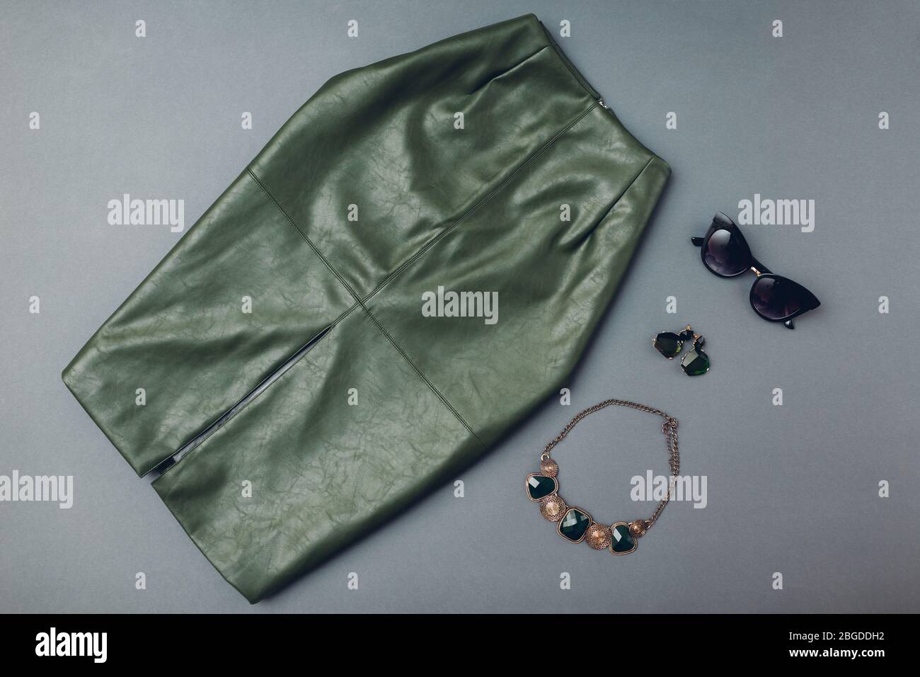 Modischer Lederrock mit Schmuck. Frühling Damenbekleidung und Accessoires.  Stylisches grünes Rock-Öko-Material. Mode Stockfotografie - Alamy