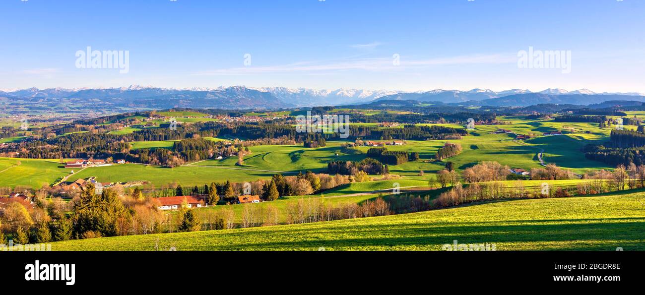 Panorama der ländlichen Allgäu Region in Bayern, Deutschland. Landschaft mit Wiesen, Wald, Hügeln und Bergkulisse Stockfoto