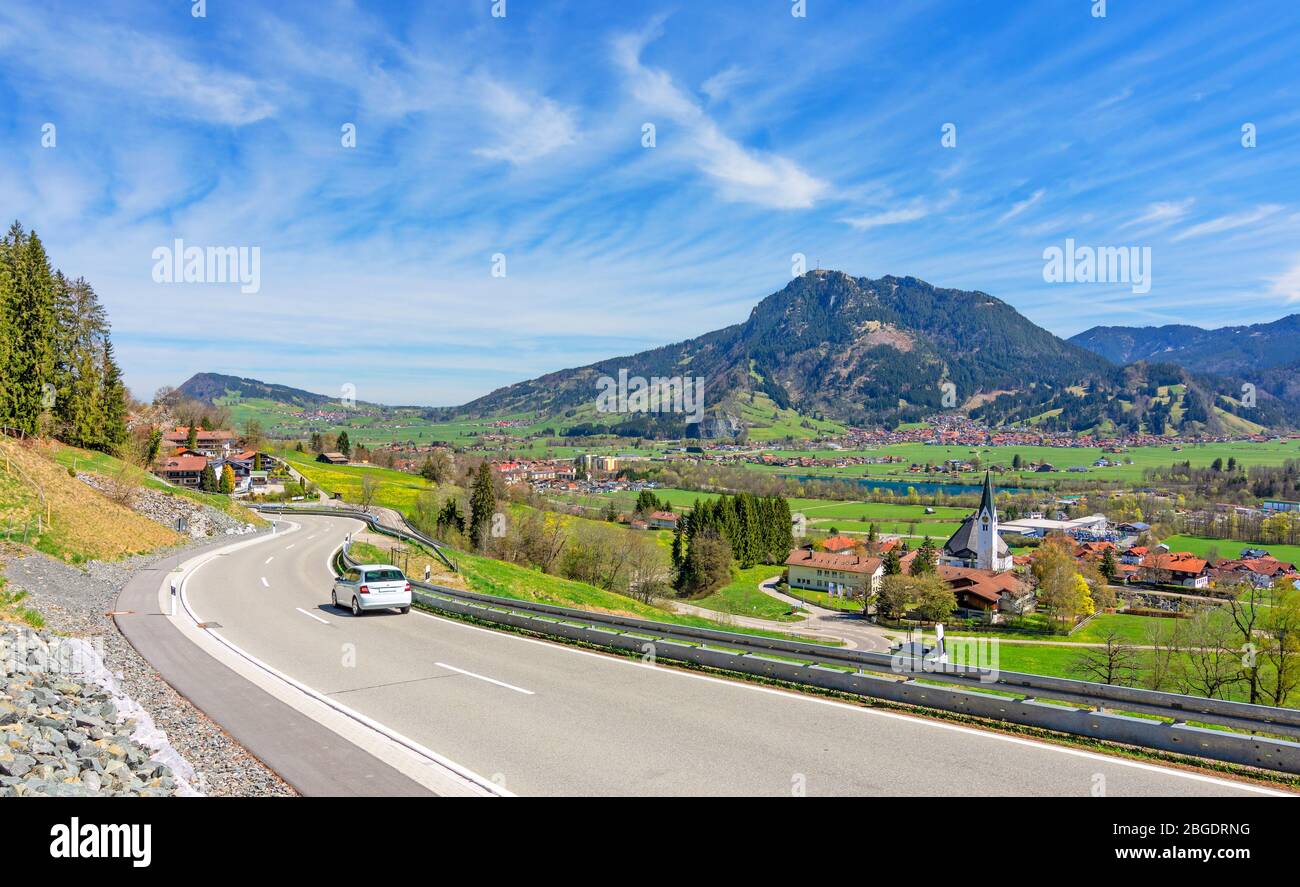 Landstraße im Allgäu im Frühling. Landschaft mit Dörfern, Wald und Grünten im Zentrum. Bayern, Deutschland Stockfoto