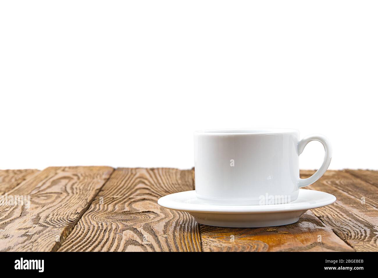 Weiße Kaffeetasse auf einem alten antiken Holztisch, vor dem weißen Hintergrund für Kopierraum. Kaffeetasse am braunen Holztisch. Stockfoto