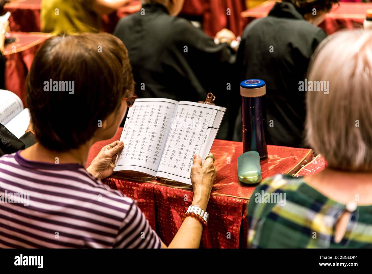 Singapur, Oktober 2019. Die Menschen beten und ehren Buddha während der Zeremonie im Buddha Tooth Relic Tempel, Chinatown. Gebetsbücher Stockfoto