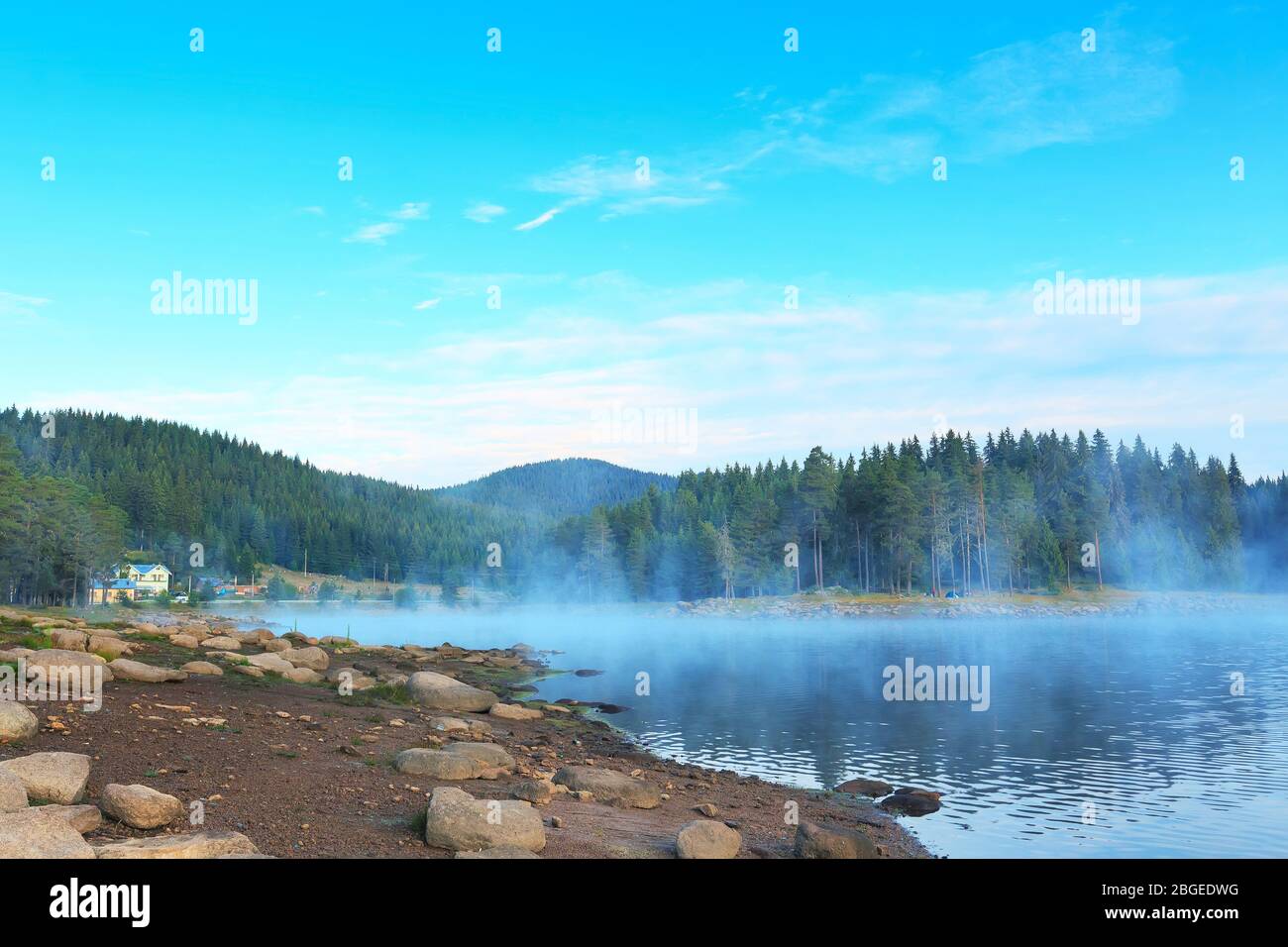Morgen neblig Nebel auf den See, die Berge Wald landschaft und Haus Stockfoto