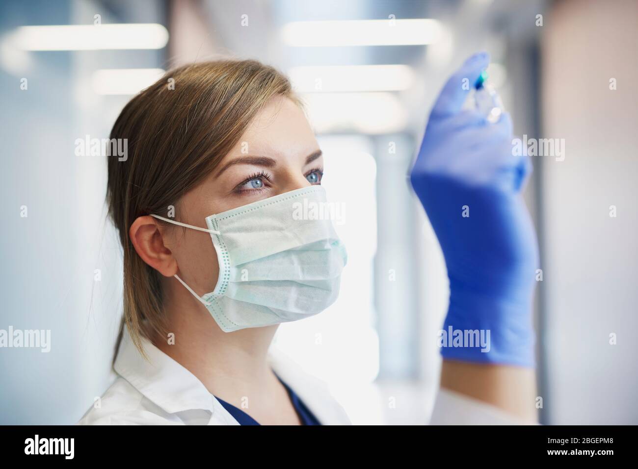 Arzt in Schutzmaske mit einem Ampulle in der Hand Stockfoto