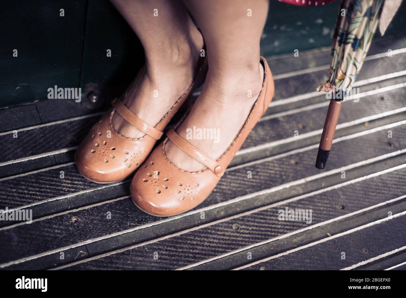 Die Füße einer Frau, die braune Schuhe mit hohem Absatz und einen  Regenschirm trägt Pateley Bridge 1940er Wochenende Stockfotografie - Alamy