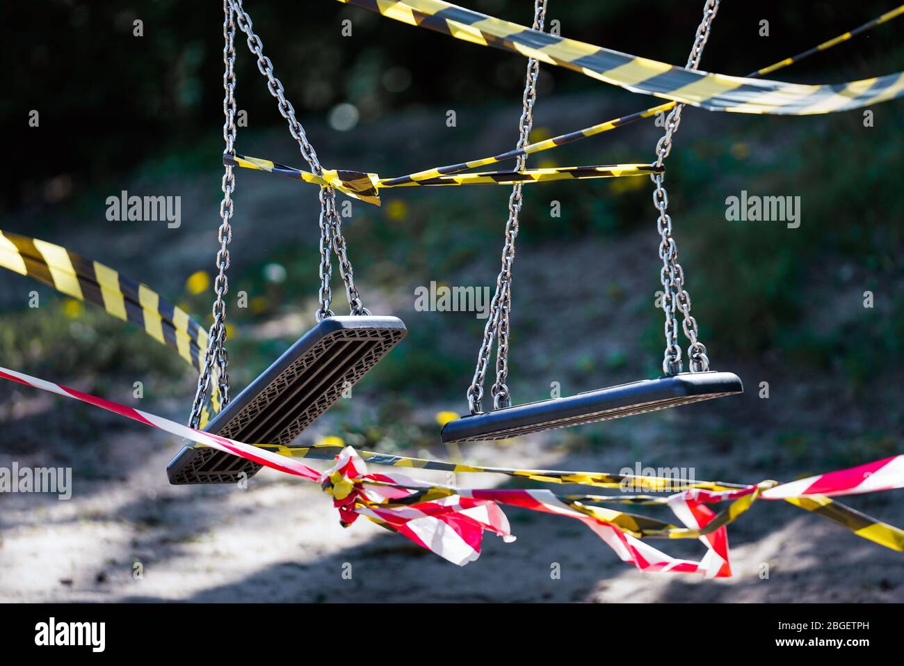 Dortmund, 21.4.2020: Mit Flatterband festgebundene Kinderschauen auf einem wegen der Coronavirus Krise (Covid-19, SARS-CoV-2) und zum Schutz vor Neuinfektionen gesperten Kinderspielplatz in einer Kleingartenanlage in Dortmund. --- Dortmund, 21. April 2020: Kinderschaukeln mit Bändern an einem Spielplatz in Dortmund gebunden. Geschlossen wegen der Coronavirus-Krise (Covid-19, SARS-CoV-2) und zum Schutz vor Neuinfektionen. Stockfoto
