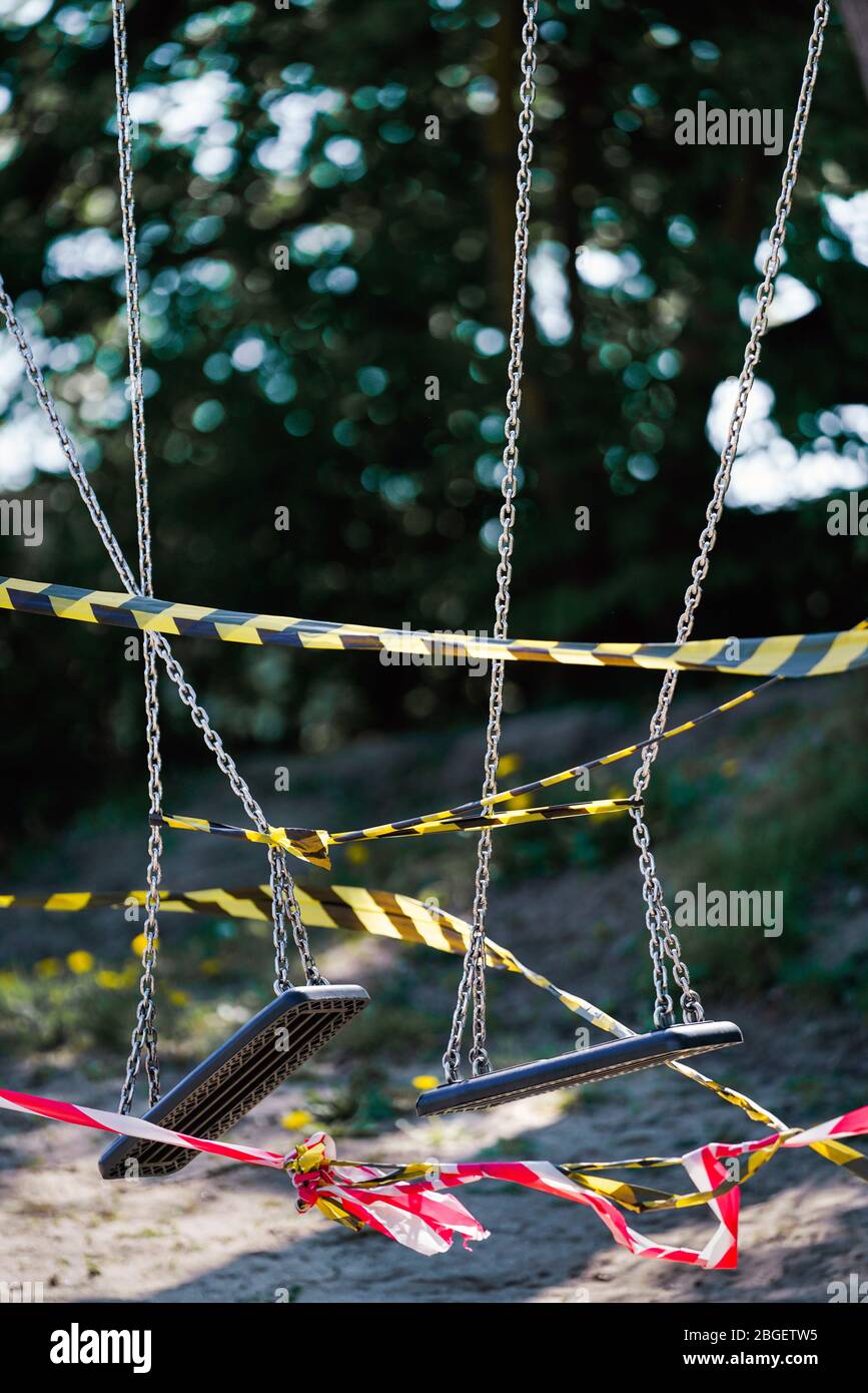 Dortmund, 21.4.2020: Mit Flatterband festgebundene Kinderschauen auf einem wegen der Coronavirus Krise (Covid-19, SARS-CoV-2) und zum Schutz vor Neuinfektionen gesperten Kinderspielplatz in einer Kleingartenanlage in Dortmund. --- Dortmund, 21. April 2020: Kinderschaukeln mit Bändern an einem Spielplatz in Dortmund gebunden. Geschlossen wegen der Coronavirus-Krise (Covid-19, SARS-CoV-2) und zum Schutz vor Neuinfektionen. Stockfoto