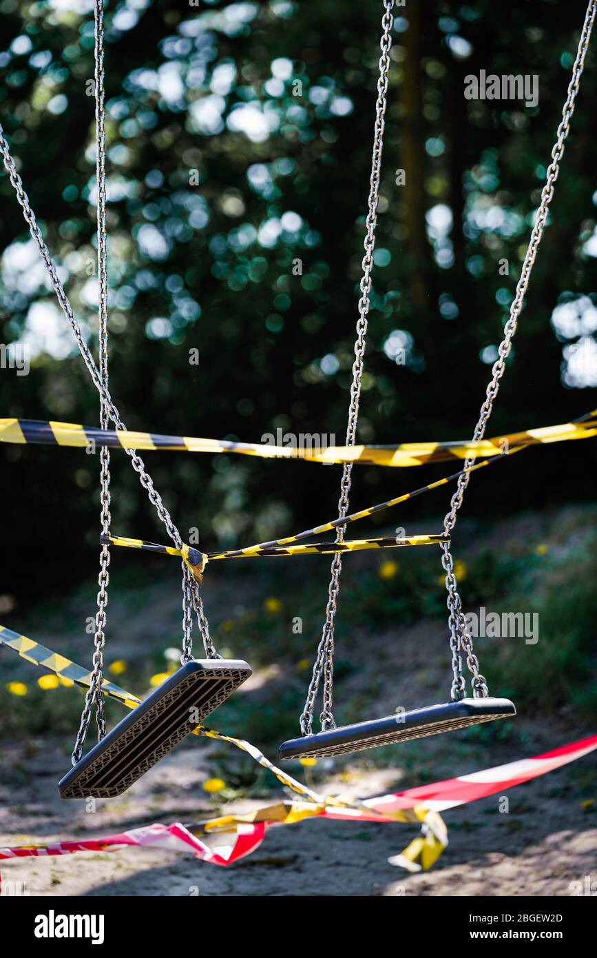 Dortmund, 21.4.2020: Mit Flatterband festgebundene Kinderschauen auf einem wegen der Coronavirus Krise (Covid-19, SARS-CoV-2) und zum Schutz vor Neuinfektionen gesperten Kinderspielplatz in einer Kleingartenanlage in Dortmund. --- Dortmund, 21. April 2020: Kinderschaukeln mit Bändern an einem Spielplatz in Dortmund gebunden. Geschlossen wegen der Coronavirus-Krise (Covid-19, SARS-CoV-2) und zum Schutz vor Neuinfektionen. Stockfoto